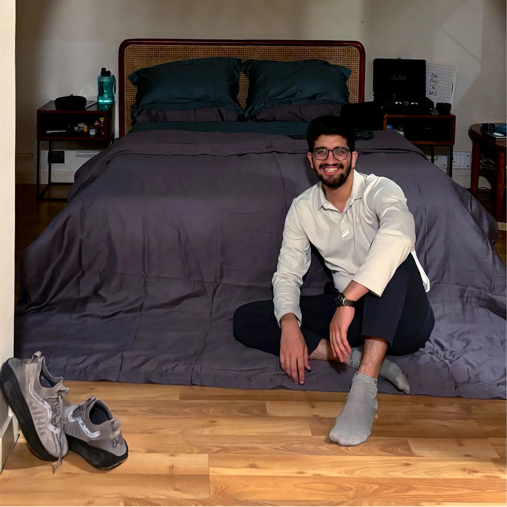 Person sitting on a bed in a room with an archway, with cozy bedding