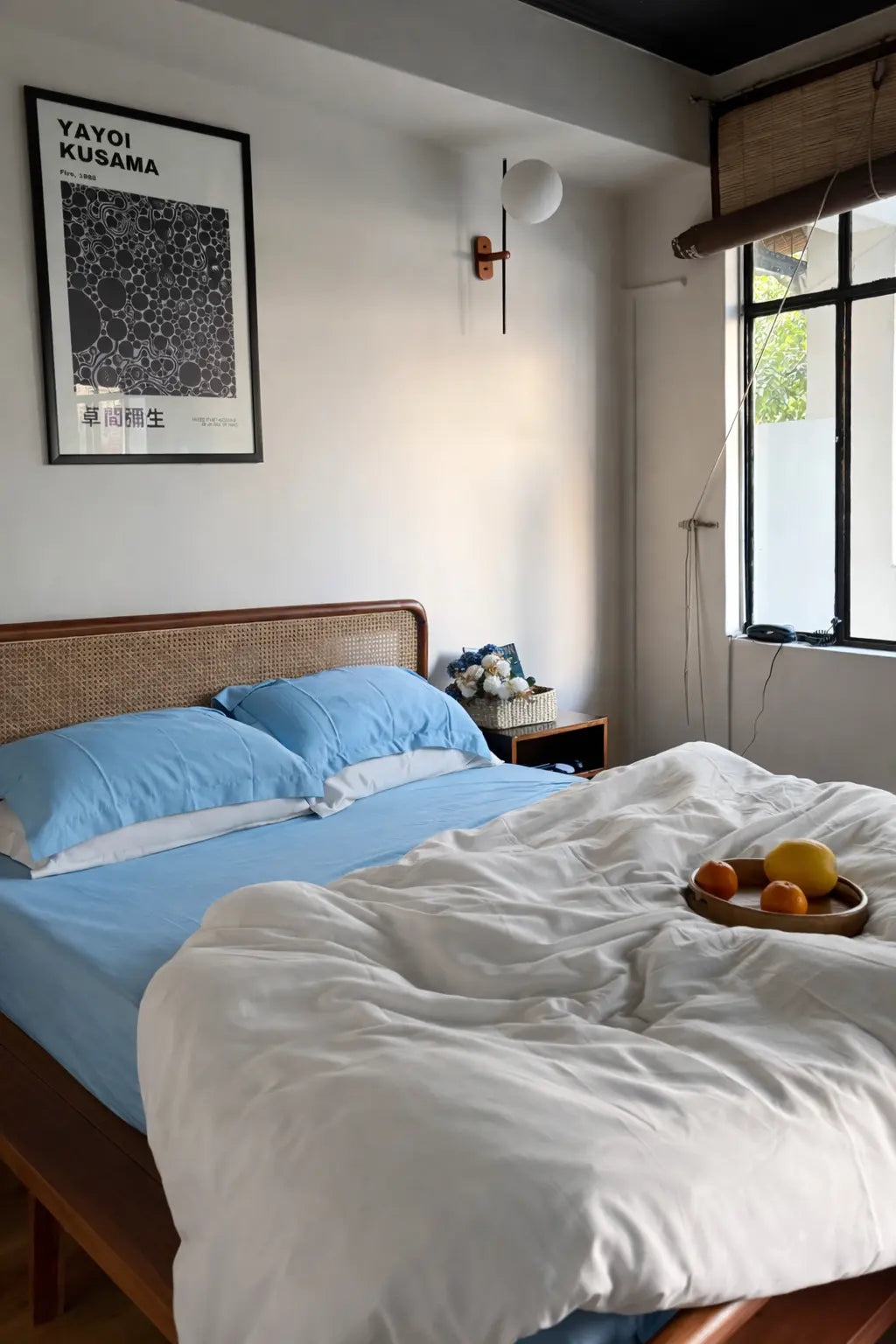 Bedroom with a bed, fruit plate, and wall art.
