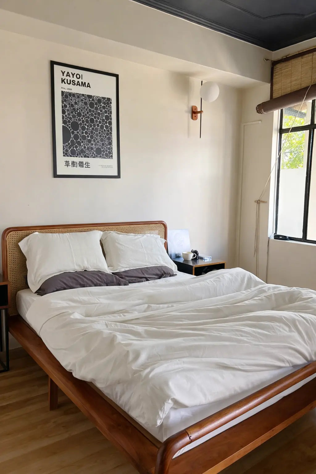 Bedroom with wooden bed, white bedding, and a framed picture on the wall.