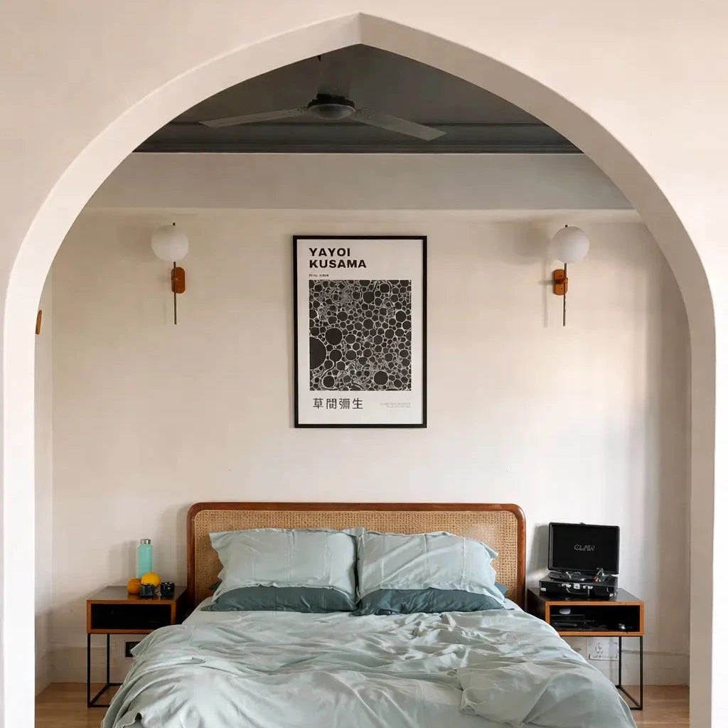 Bedroom with wooden bed, green bedding, and framed poster on wall.