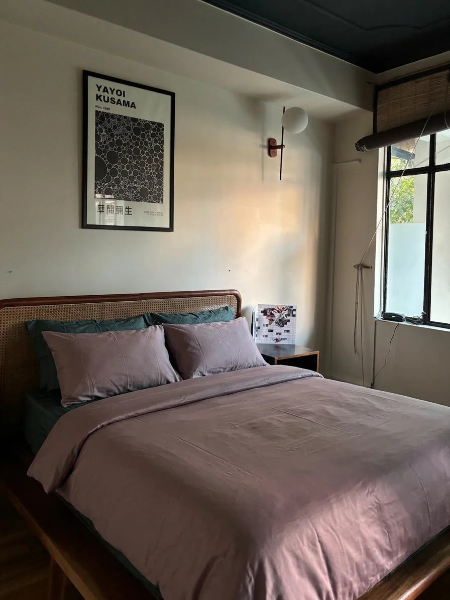 Bedroom with a bed, pillows, and a lamp on a nightstand.