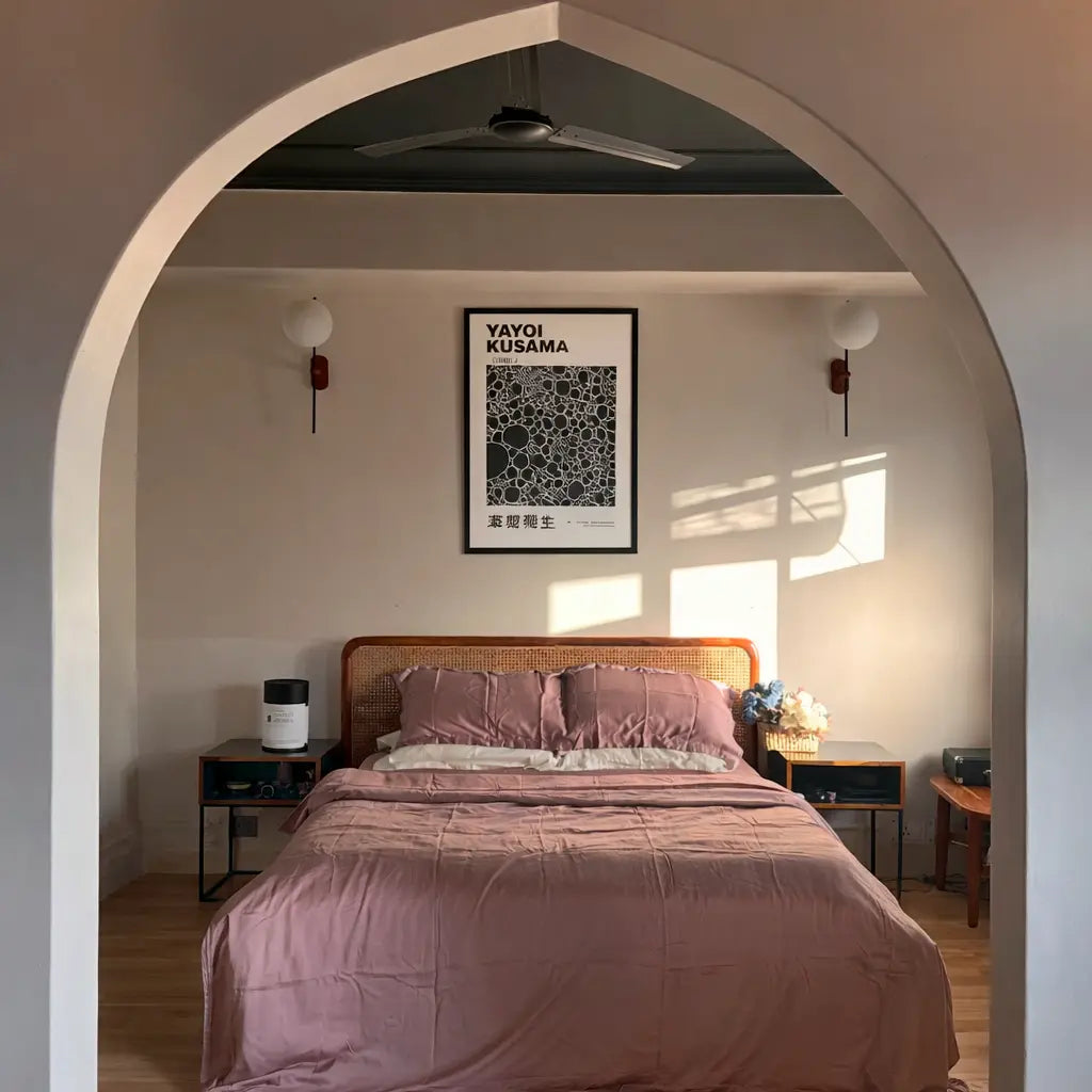Bedroom with pink bedding, a framed artwork on the wall.